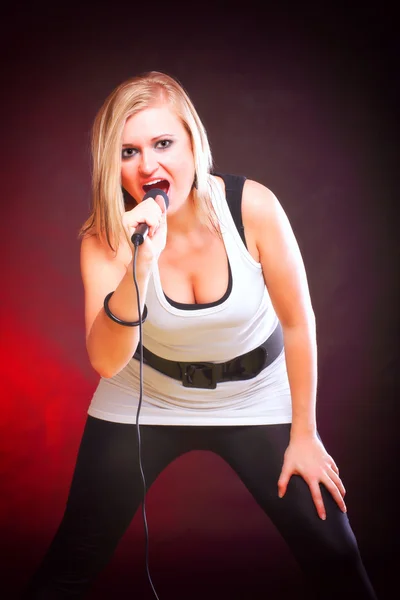Женщина поет рок-песню микрофон — стоковое фото