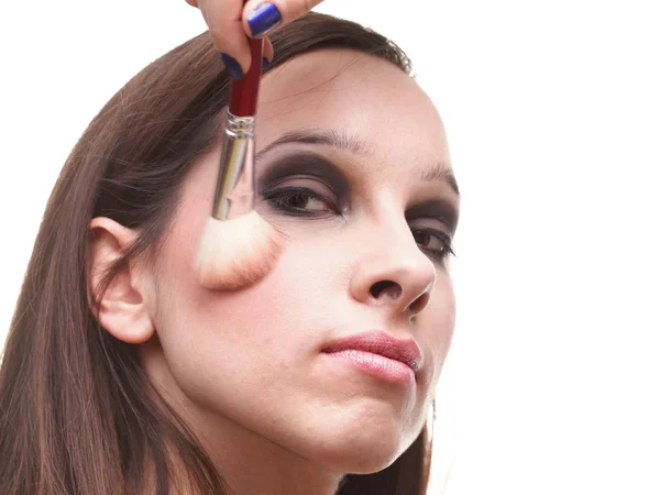 Vacker ung brunett kvinna ansöker pulver med en pensel — Stockfoto