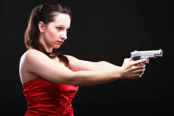 Sexy giovane donna pistola su sfondo nero Fotografia Stock