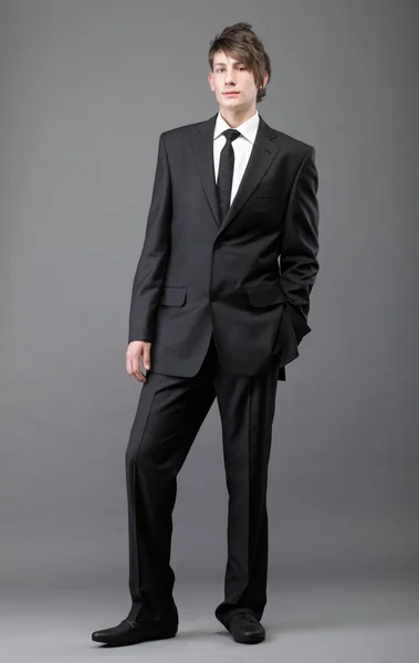 Молодой бизнесмен черный костюм случайный галстук на сером фоне — стоковое фото