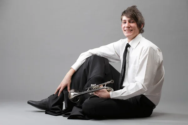 Porträtt av en ung man och hans trumpet — Stockfoto