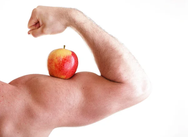 在男人的二头肌肌肉上红红的苹果 — 图库照片