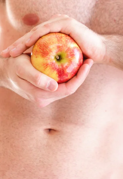 Muscle naked young man torso red apple in hands — Stock Photo, Image