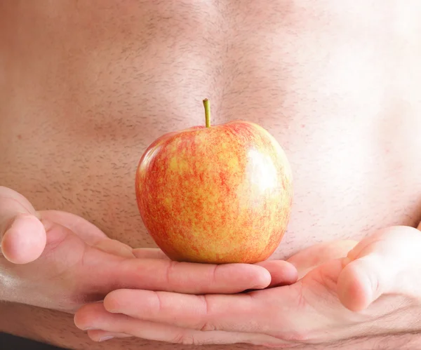 Muscle naked young man torso red apple in hands — Stock Photo, Image