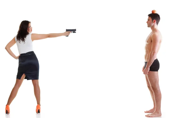 Giovani uomini con mela rossa sulla testa Giovane donna bruna con pistola isolata su bianco tutta la lunghezza — Foto Stock