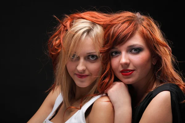 Two happy young girlfriends black background — Stock Photo, Image