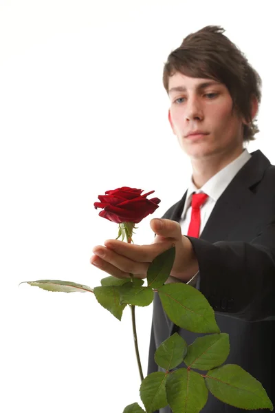 Joven presentando una rosa roja flor aislada — Foto de Stock