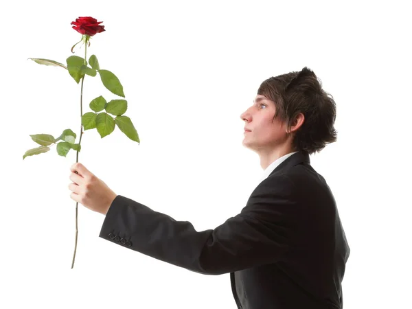 Νεαρός άνδρας παρουσιάζει ένα λουλούδι - κόκκινο τριαντάφυλλο απομονωθεί — Φωτογραφία Αρχείου