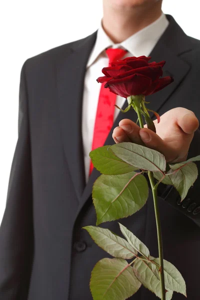 Junger Mann präsentiert eine Blume rote Rose isoliert — Stockfoto