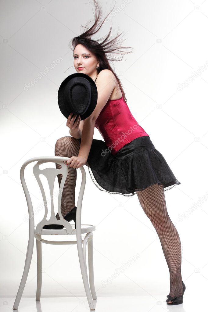 Showgirl woman dance in red corset chair white isolated