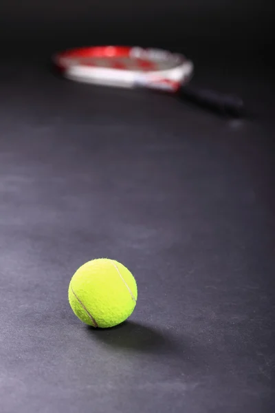 Tennisschläger und Bälle auf schwarzem Hintergrund — Stockfoto