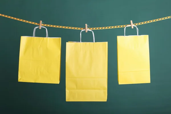Покупки желтые подарочные пакеты на зеленом фоне — стоковое фото