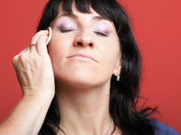 Frau bemalt Gesicht mit Make-up — Stockfoto