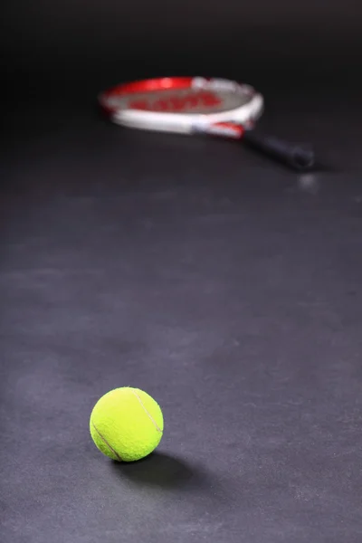 Tennisschläger und Bälle auf schwarzem Hintergrund — Stockfoto