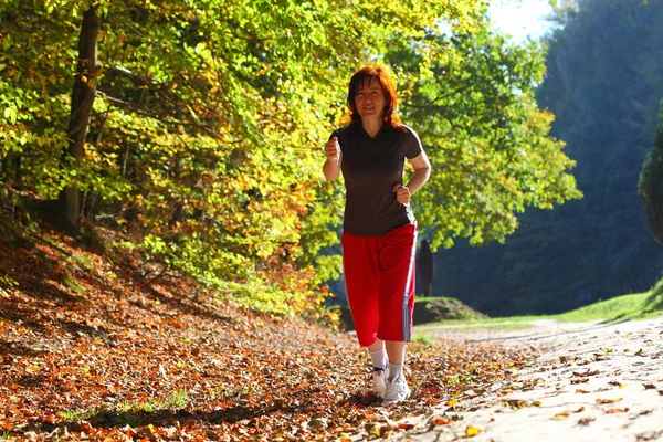 Vrouw lopen Kruis land parcours in herfst bos — Stockfoto