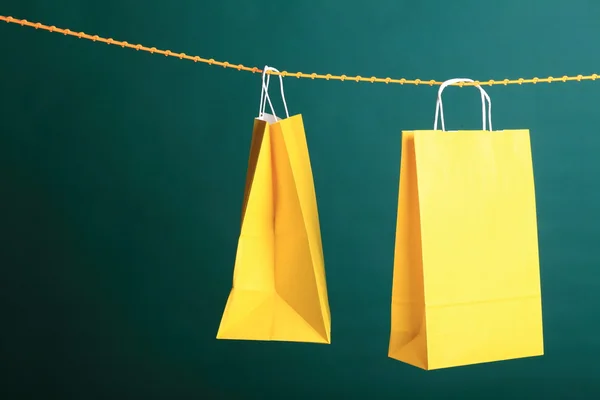 Yeşil zemin üzerine sarı hediye çanta alışveriş — Stok fotoğraf