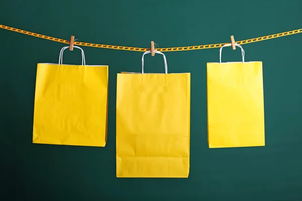 Shopping yellow gift bags on green background — Stock Photo, Image