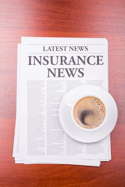 The newspaper INSURANCE NEWS and coffee — Stock Photo, Image