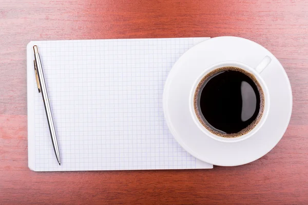 Taza de café en el bloc de notas — Foto de Stock
