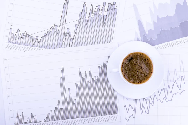 Cup of coffee and graphs — Stock Photo, Image