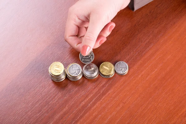 Hand puts a coin in the pile — Stock Photo, Image