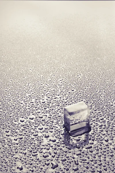 Pedazo de hielo en gotas de agua — Foto de Stock
