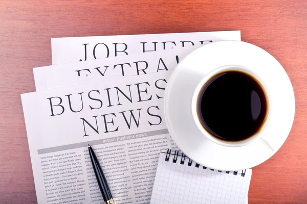 Business newspaper, notebook and cup of coffee — Stock Photo, Image