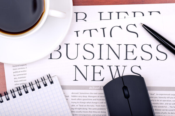 Деловая газета, ноутбук, мышь и чашка кофе
