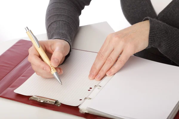 Une femme écrit au stylo sur papier. Isolé sur fond blanc — Photo