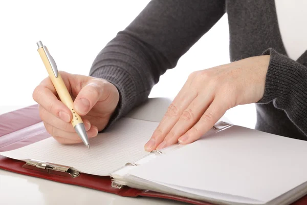 Una mujer escribe a pluma sobre papel. Aislado sobre fondo blanco — Foto de Stock