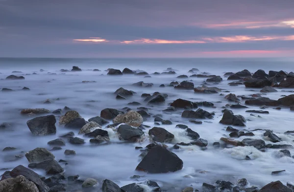Napkelte előtt, sziklás strand — Stock Fotó