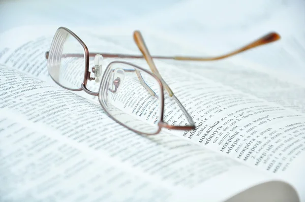 Eyeglasses on open book — Stock Photo, Image