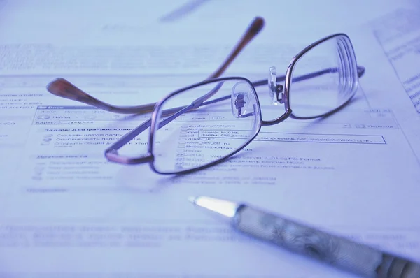 Brille und Bleistift auf einem Dokument lizenzfreie Stockfotos