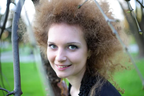 stock image Portrait of a girl among the branches of trees