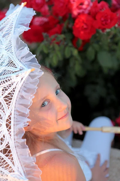 Smiling girl peeks out from under the lace parasol — Stock Photo, Image