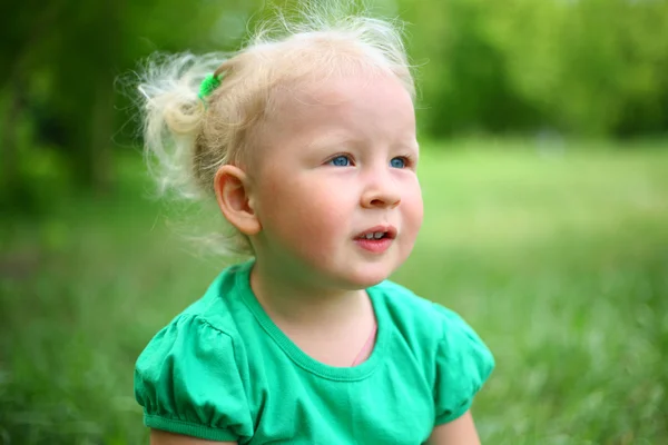 L'enfant est assis sur l'herbe — Photo