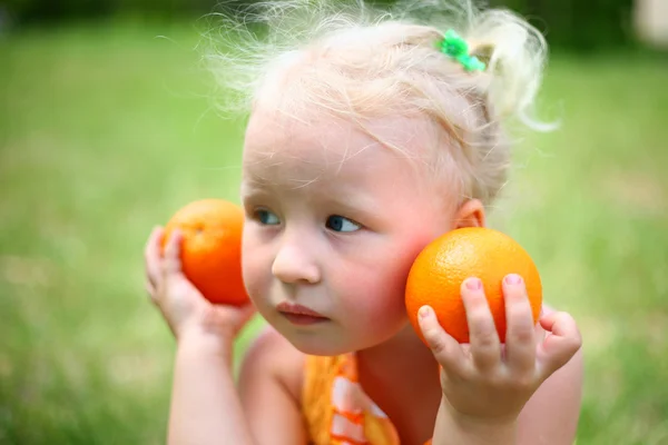 Uma criança com laranjas — Fotografia de Stock