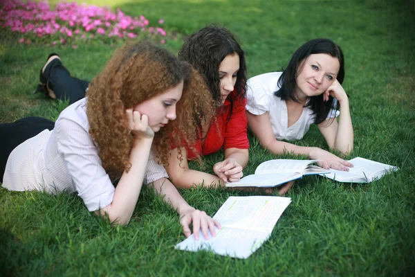 Trzy dziewczyny na trawie gotowy do lekcji — Zdjęcie stockowe