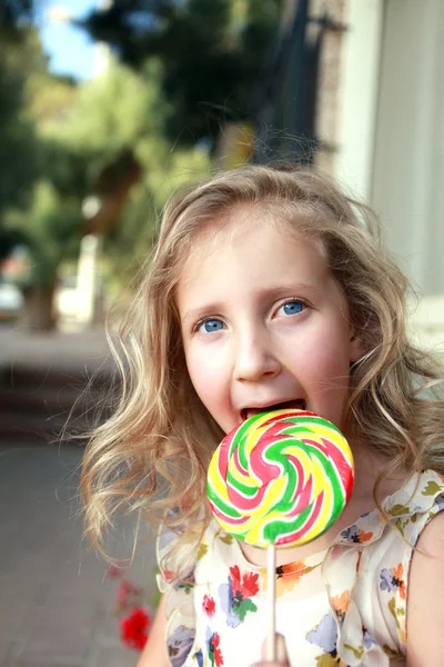 Uma criança com um enorme doce — Fotografia de Stock