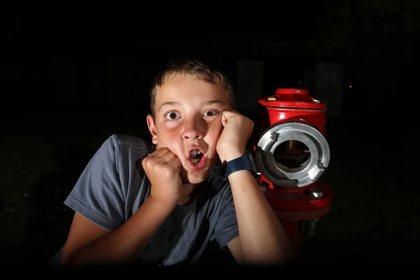 Um rapaz perto da boca-de-incêndio — Fotografia de Stock