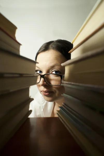 Girl peeking from the books — Stock Photo, Image