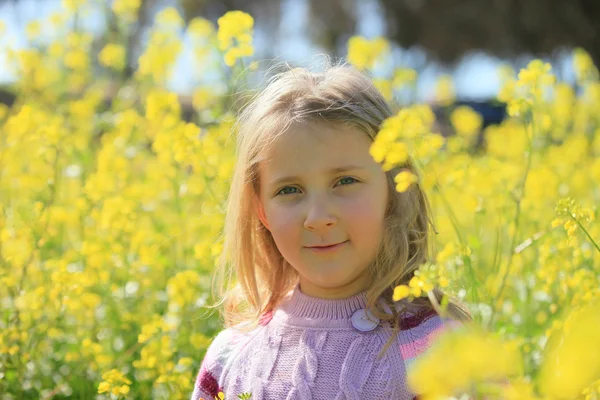 Portret dziewczyny na tle żółte kwiaty — Zdjęcie stockowe