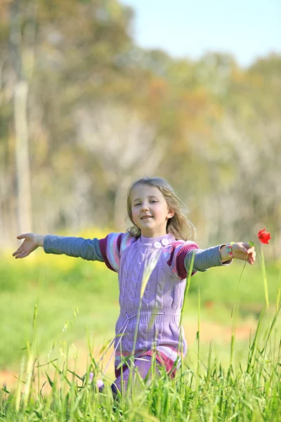Retrato de uma menina correndo ao redor da grama — Fotografia de Stock