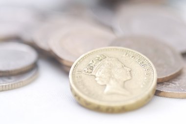 Spilled coins, focus on £1 coin. clipart