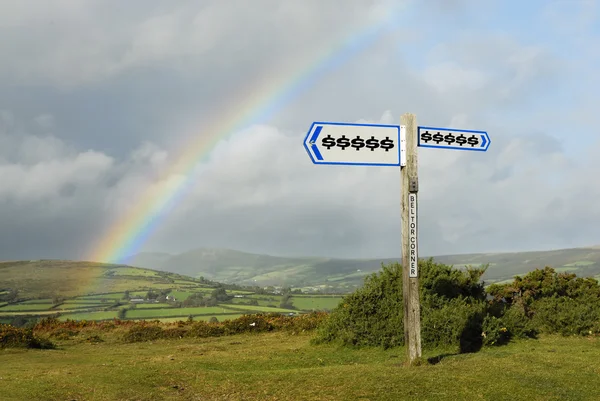 Dollar Signs on Signpost, Rainbow in Background. — Stock Photo, Image