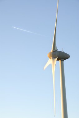 bir rüzgar türbini ve uçak iz buharı.