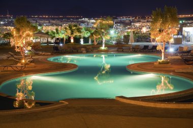 Luxury hotel pool by night clipart