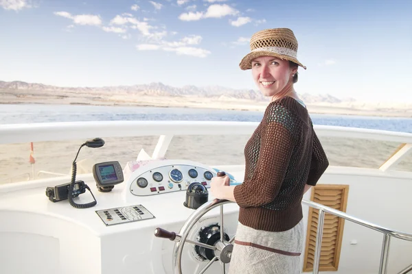 Attractive young woman steering a boat — Stock Photo, Image