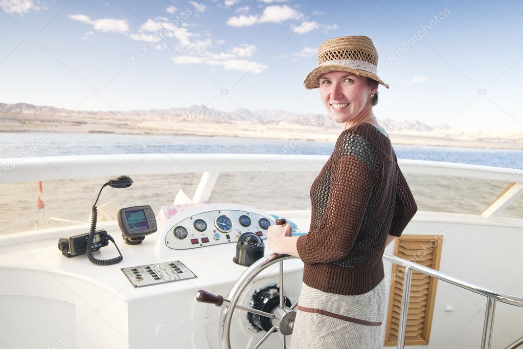 Attractive young woman steering a boat
