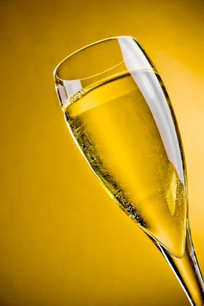 Champagne in a glass on golden background — Stock Photo, Image